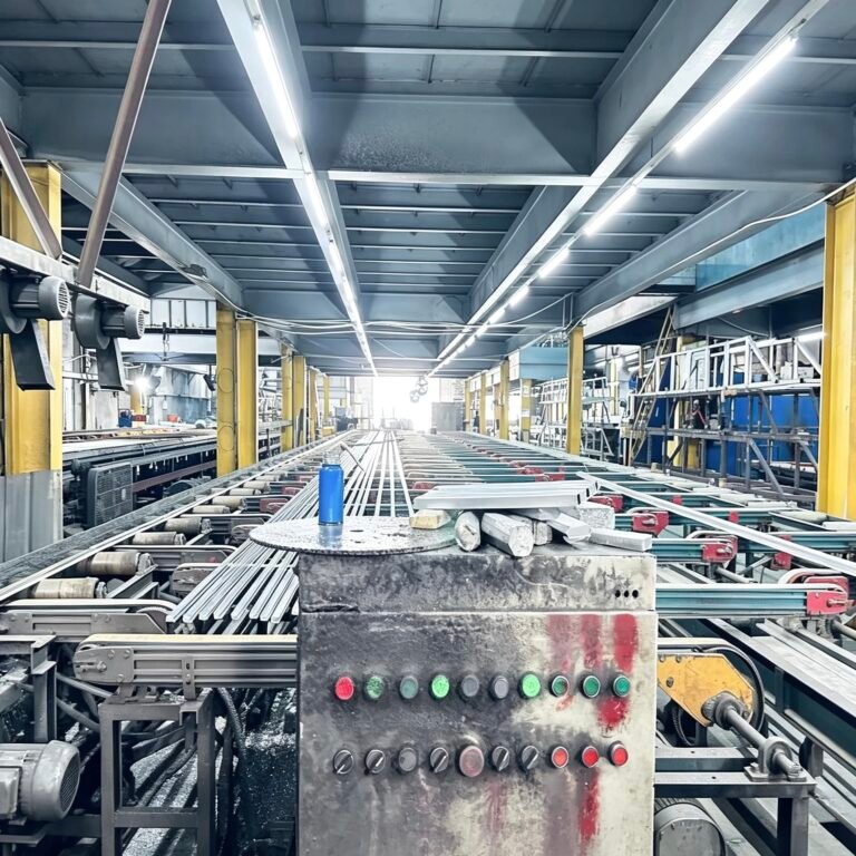 Vanway Tech aluminum extrusion profiles moving on the conveyor belt in the factory production line, showing the automated manufacturing process of industrial-grade aluminum alloy profiles before surface treatment